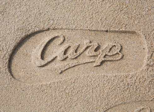 カープスタンプビーチサンダル 砂浜にロゴがうかびあがる