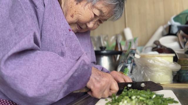 映画「104歳、哲代さんのひとり暮らし」畑で育てたわけぎを刻んで料理する哲代さん