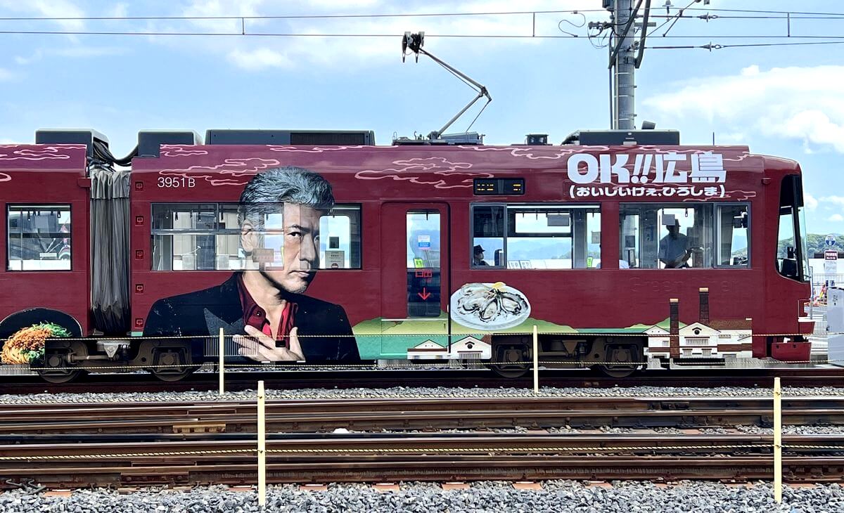 吉川晃司・奥田民生がドーンとラッピング!広電の路面電車にオーチーコーチー電車が登場