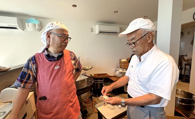 宮島口「花見堂」で、みせん煎餅の焼き方を教える岩村さん
